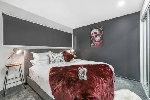 a bedroom with a large bed with a red blanket at Serenity in Central Maleny in Maleny