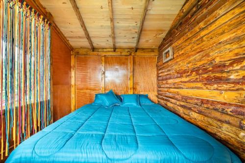 uma cama num quarto com uma parede de madeira em Casiopea Glamping em Tabio