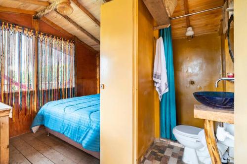 uma casa de banho com uma cama e um lavatório num quarto em Casiopea Glamping em Tabio