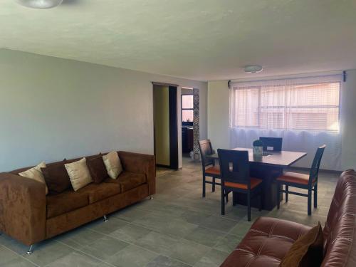sala de estar con sofá y mesa en Suites Incoreli 4, Centro Pachuca de Soto, en Pachuca de Soto