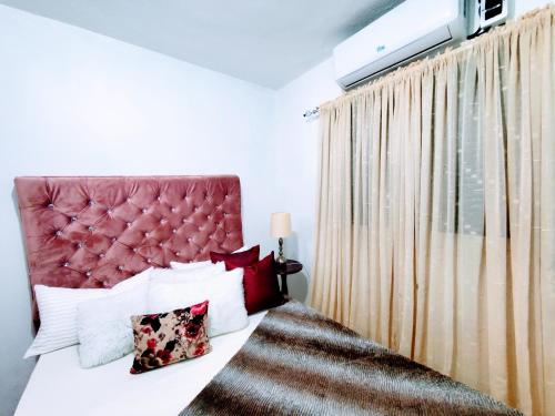 1 dormitorio con 1 cama con cabecero rojo en Como en Casa, en Mandinga
