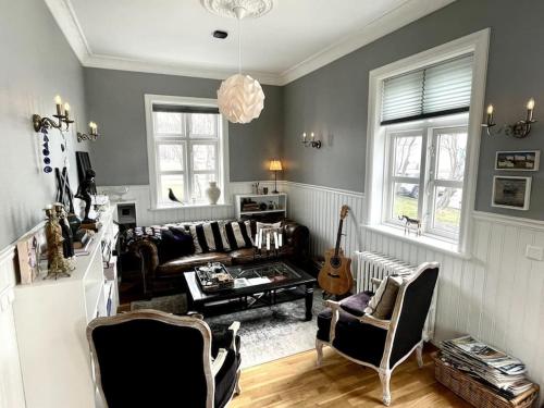 a living room with a couch and a guitar at The Foreman house - an authentic town center Villa in Húsavík