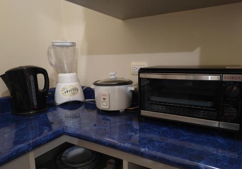 a kitchen counter with a blender and a microwave at Hotel Bamboo Aeropuerto in Alajuela City