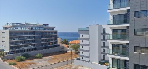 an apartment building with the ocean in the background at Kaps Home - Miramar D4 in Praia