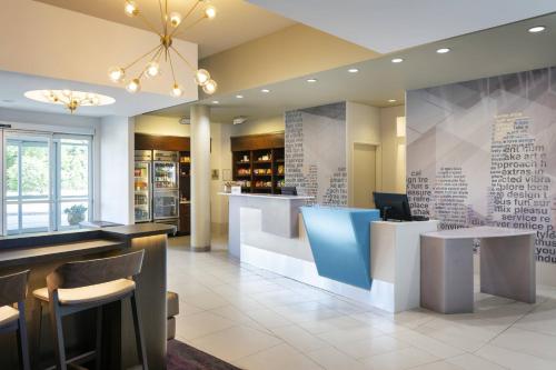 a restaurant with a bar with blue chairs and tables at SpringHill Suites by Marriott Philadelphia Airport / Ridley Park in Ridley Park