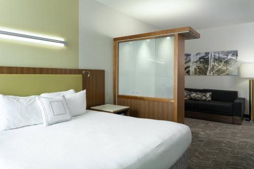 a hotel room with a bed and a couch at SpringHill Suites by Marriott Philadelphia Airport / Ridley Park in Ridley Park