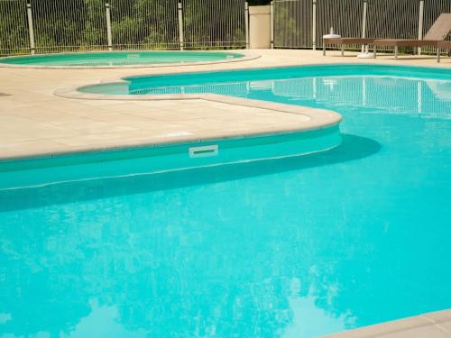 a swimming pool with blue water at Lac Bleu 39 en 40 combi in Lacapelle-Marival