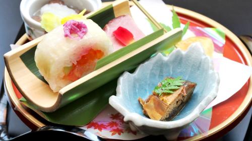 une assiette de nourriture avec des sushis et des baguettes dessus dans l'établissement Oyado Yamashita, à Kanazawa