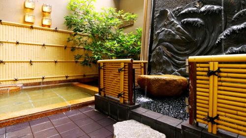 金沢市にあるお宿　やましたの黄色い椅子2脚と噴水のある庭園