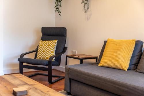 a living room with a couch and a chair at Beryl - 2 Bedroom Flat with Parking in Southampton