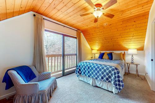 a bedroom with a bed and a ceiling fan at Creekside Cottage in Blairsville