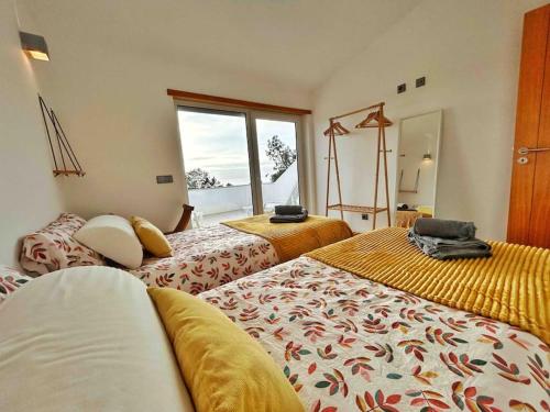 een hotelkamer met 2 bedden en een raam bij Olive Tree Sunset View - V3 luxo vista mar in Aljezur