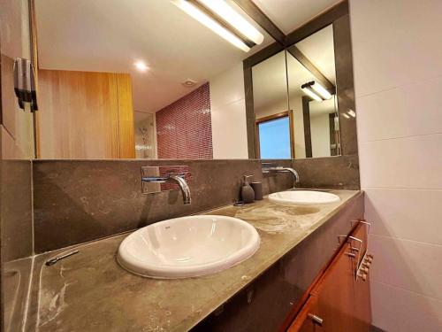 a bathroom with two sinks and a large mirror at Olive Tree Sunset View - V3 luxo vista mar in Aljezur