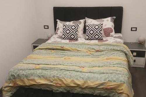 um quarto com uma cama grande e almofadas em ستوديو فندقي مع مسرح منزلي روعه وواي فاي em ‘Ezbet `Abd el-Ḥamîd