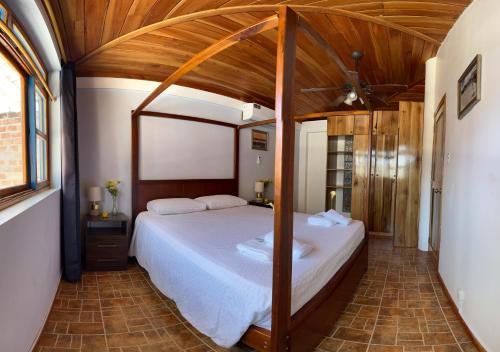 a bedroom with a large bed with a wooden ceiling at casa munay in Canoa