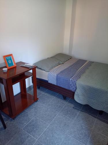 um pequeno quarto com uma cama e uma mesa em Igr. Planta Baja em Puerto Iguazú