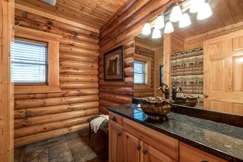 een badkamer in een blokhut met een wastafel en een spiegel bij Dreamscapes in Gatlinburg