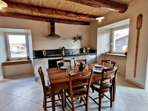 une salle à manger avec une table et des chaises en bois dans l'établissement Gîte rénové au cœur de l'Auvergne - FR-1-582-336, à Arlempdes