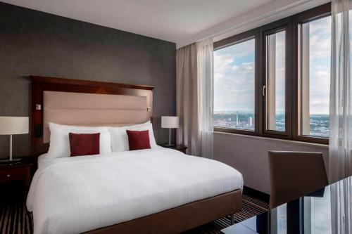 a bedroom with a large bed with a large window at Frankfurt Marriott Hotel in Frankfurt/Main