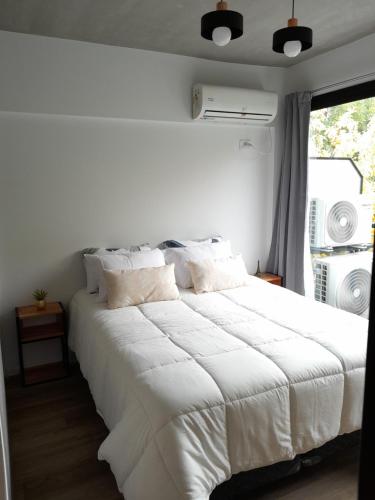 a bedroom with a large white bed with a window at Apartamento Nuevo a Estrenar in Buenos Aires
