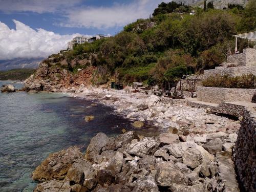 a rocky shoreline with rocks and the water at Villa Golda, The whole house Biker Friendly in Rijeka Reževići
