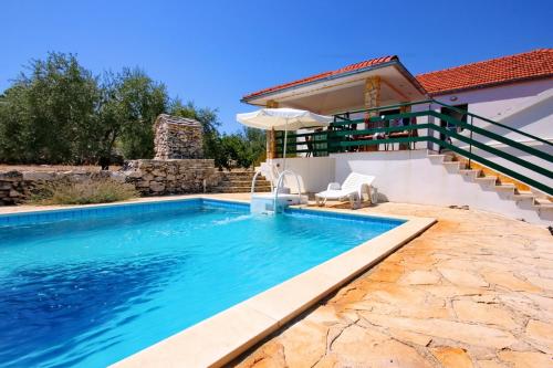 - une piscine en face d'une maison dans l'établissement Family friendly house with a swimming pool Cove Gradina, Korcula - 7552, à Vela Luka