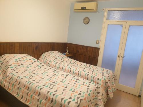 een slaapkamer met een bed met een dekbed erop bij FourDoor in Guaymallen