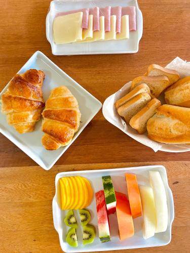 una mesa de madera con cuatro platos de comida. en 1QuartoPra2 Centro Búzios, en Búzios