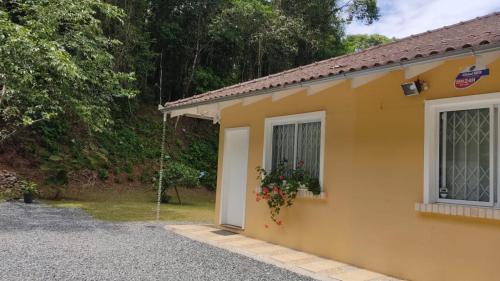 una casa amarilla con puerta y ventana en Bela Vista Hospedagem en Joinville