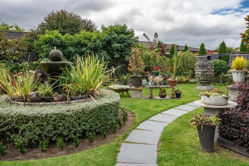 a garden with a fountain and many plants at Dunrovin Motel in Taupo