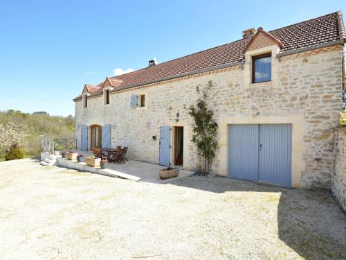 una casa in pietra con garage e patio di Charming holiday home with pool a Lavercantière