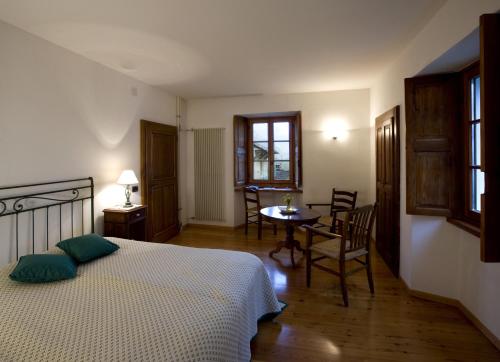 a bedroom with a bed and a table and chairs at Pensione Ca' Serafina in Lodano