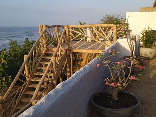 a wooden staircase next to the ocean with a potted plant at El Secreto in Dibulla