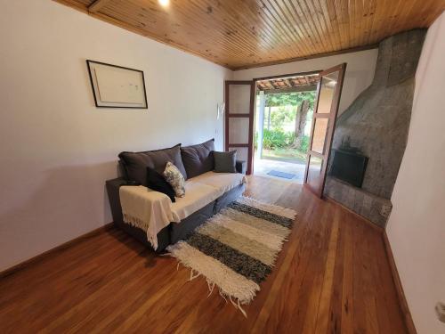 a living room with a couch and a tv at Recanto da Natureza- Chalé in Gonçalves