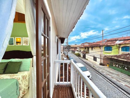 a balcony of a house with a bed and a street at 1QuartoPra2 Centro Búzios in Búzios