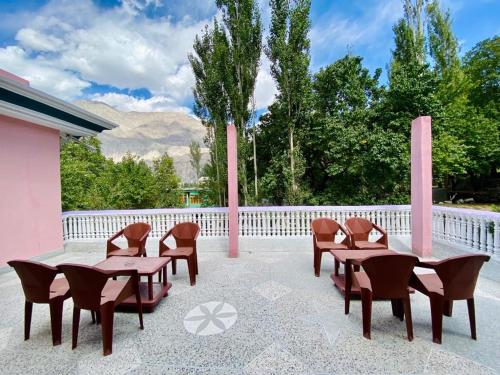 un patio con mesa, sillas y una valla en North Palace Khaplu en Khaplu