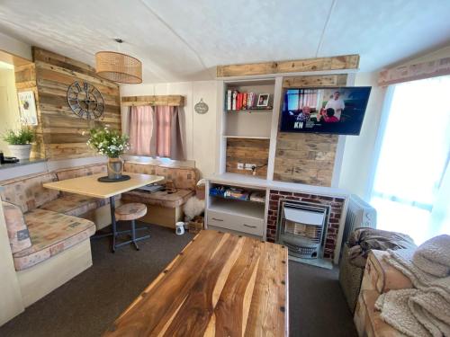 a living room with a table and a desk at Trimingham Static Van in Trimingham