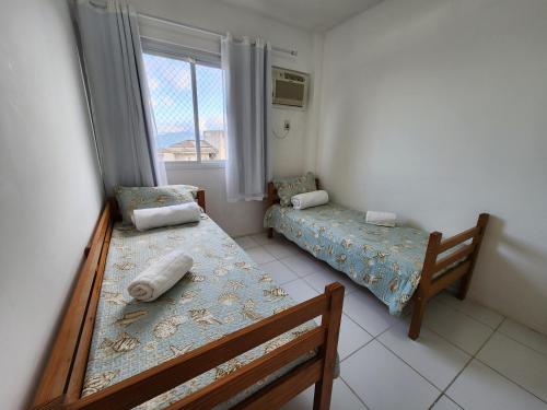 Cette petite chambre comprend 2 lits et une fenêtre. dans l'établissement AP Alecrim Porto Real Suítes com Tela de Proteção Praia Privativa, à Mangaratiba