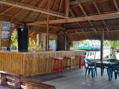 un ristorante con bar con tavoli e sedie di Hotel Little Queen Lobster a Laguna de Perlas