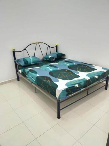 een bed met een blauw en wit dekbed en kussens bij BEACHWALK HOMESTAY in Kuala Kurau