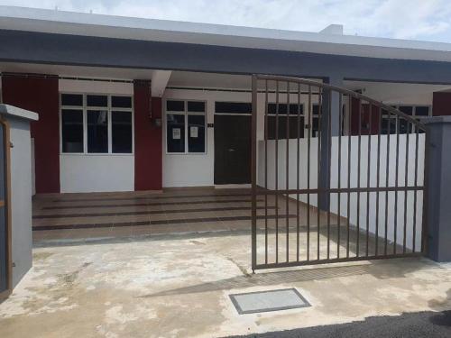 een gebouw met een poort ervoor bij BEACHWALK HOMESTAY in Kuala Kurau