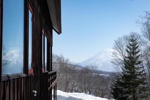a building with a view of a snow covered mountain at Niseko HyKrots IKIGAI Village in Rankoshi