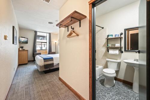 a bathroom with a toilet a sink and a bed at Hotel Leavenworth in Leavenworth