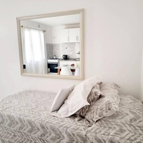 a bedroom with a bed with a mirror on the wall at NUDE in Caleta Olivia