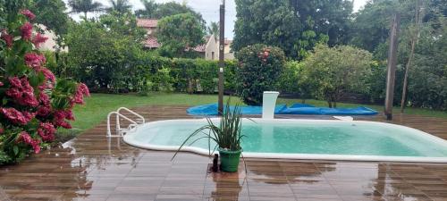a swimming pool with a potted plant in a yard at Casa em Caldas - PISCINA SOLAR E ELETRICA in Caldas Novas