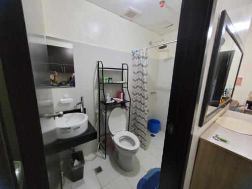 a small bathroom with a toilet and a sink at Kasara relaxing abode in Manila