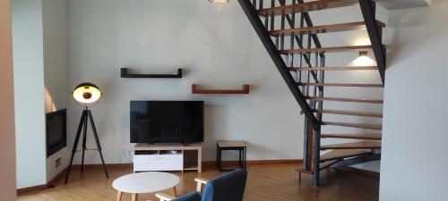 uma sala de estar com uma escada e uma televisão em Ponta Delgada Apartment T3 em Ponta Delgada