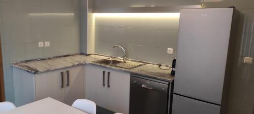 a small kitchen with a sink and a refrigerator at Ponta Delgada Apartment T3 in Ponta Delgada