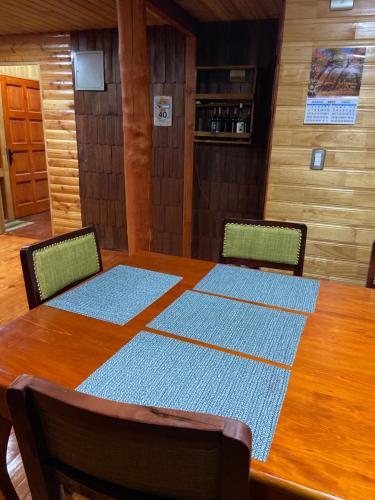 a dining room table with two chairs and a wooden table at Hostería Lenca in Puerto Montt