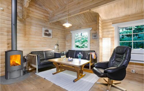 a living room with a fireplace in a log cabin at Holiday Home Holmegårdsvej Rønne V in Hasle